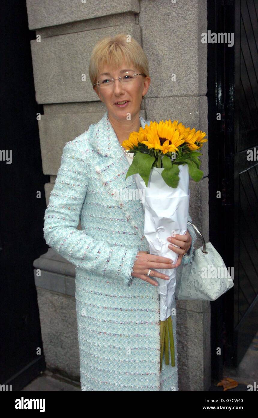 New Minister for Education and Science, Mary Hanafin, with a bunch of flowers given to her by a well-wisher, poses for a photo at the gates of Leinster House, after the Taoiseach announced his Cabinet re-shuffle. Stock Photo