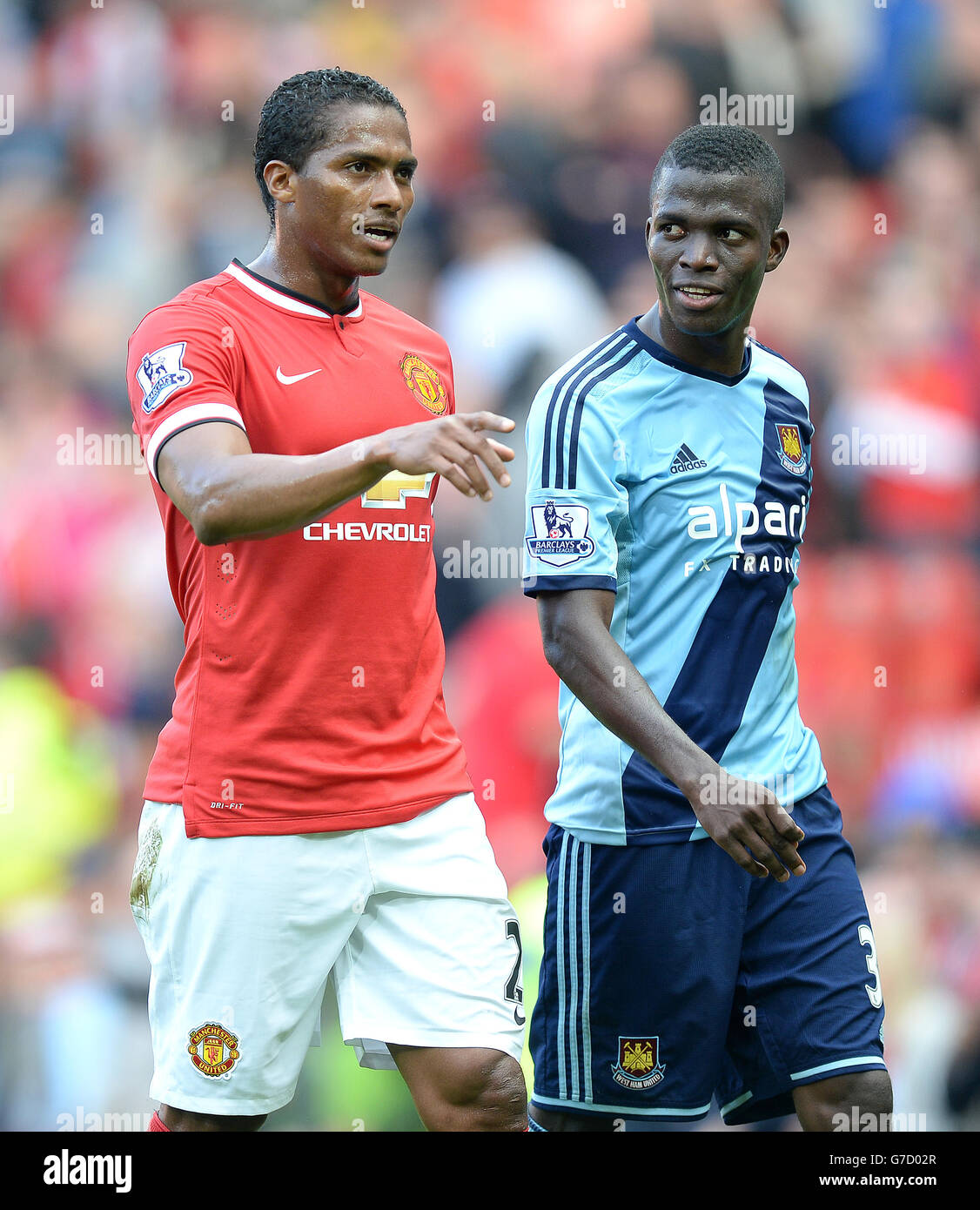 Manchester United's Antonio Valencia leaves the field with West Ham United's Enner Valencia during the Barclays Premier League match at Old Trafford, Manchester. Stock Photo