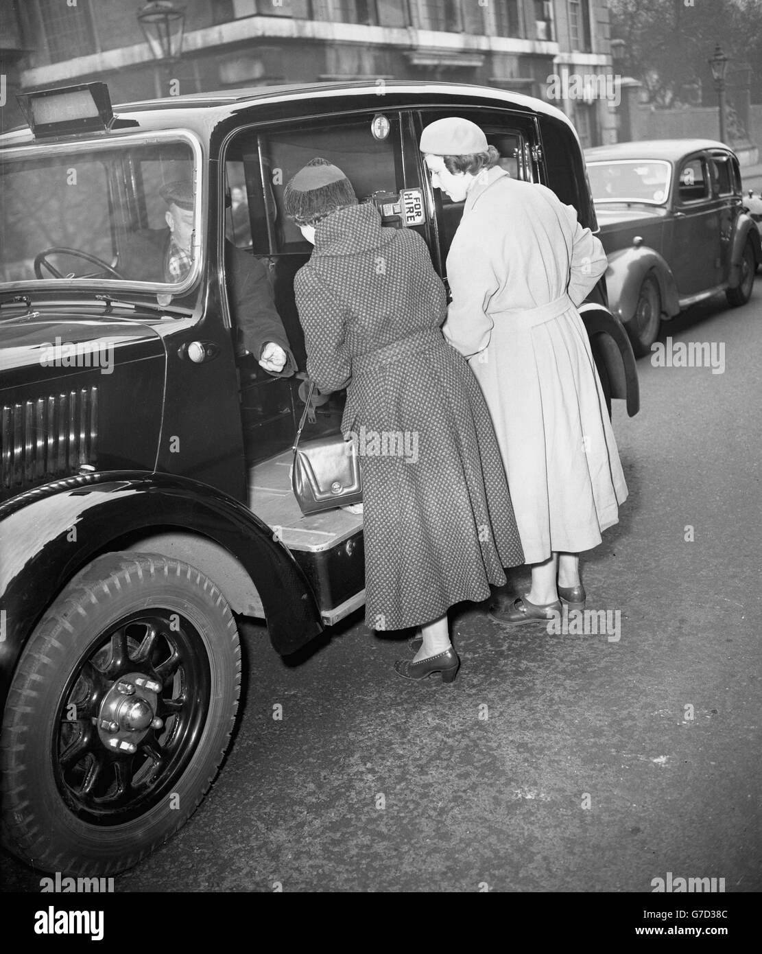 Princess Alexandra of Kent (r) and an unidentified friend paying off a taxicab on arrival at Marlborough House, London, to see the Princess' grandmother, Queen Mary, whose condition is causing increasing anxiety. Stock Photo