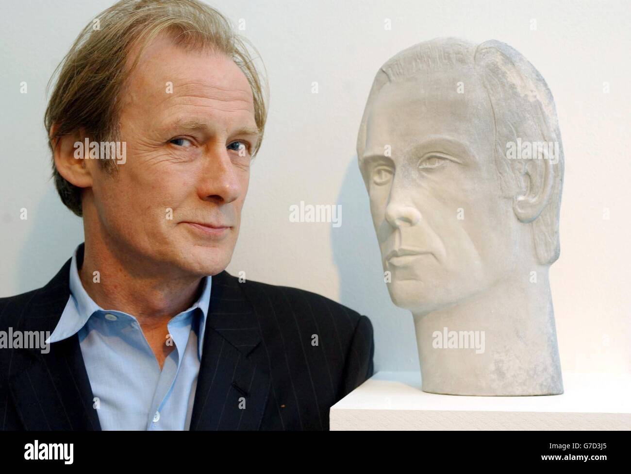 Actor Bill Nighy poses with a bust of himself by sculptor Glenys Barton - which is featured in the forthcoming film 'Enduring love' (starring Nighy, Daniel Craig and Samantha Morton) - during a photocall at Flowers East Gallery in east London. The film which opens next week features in The Times bfi London Film Festival. The bust forms part of an exhibition of Barton's work showing at Flowers East Gallery til 20 November. Stock Photo