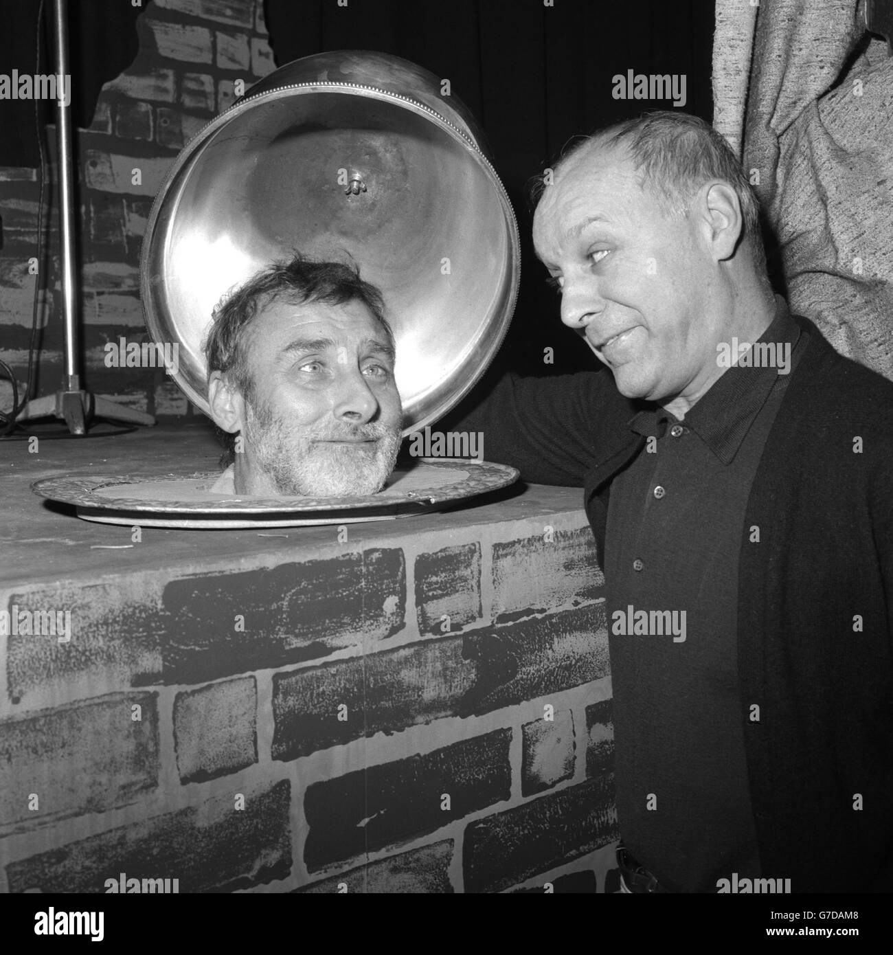 Actor Bill Kerr (r) lifts the lid on a serving dish only to find comedy actor Spike Milligan.. Actor Bill Kerr (r) lifts the lid on a serving dish only to find comedy actor Spike Milligan. Stock Photo