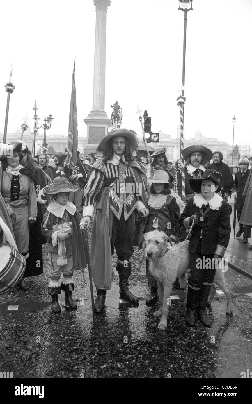 The scene in Whitehall, where on a nearby site on January 30th 1649 the reign of King Charles I ended with his execution. The commemorative ceremony held at the equestrian statue of the King attended by Count Nikolai Tolstoy (centre), a Commanding Officer of Grenvile's Regiment (of the Sealed Knot Society of Cavaliers), and supporters of the unit, wearing Civil War period dress. With them at the ready is Rory, a Wolf hound. In the background is the King's statue in Trafalgar Square which marks the spot in which his own executioners were beheaded. Stock Photo