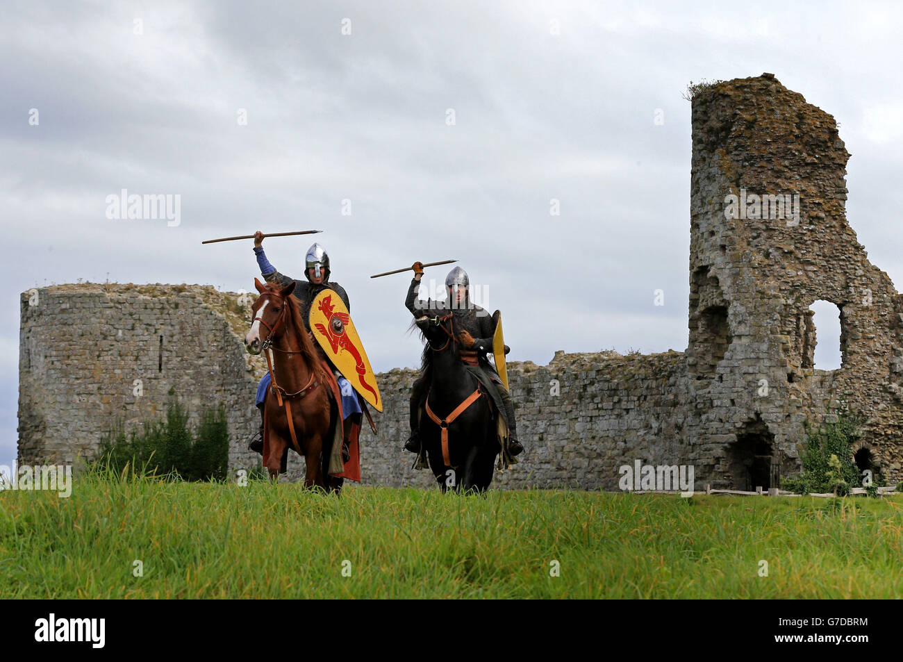 Two Norman cavalry re-enactors wearing riveted maille hauberks, and carrying swords, shields and lances, set out from Pevensey Castle in East Sussex, to ride over two days from the area where the Normans landed to Battle Abbey and the site of the Battle of Hastings, ahead the re-enactment of the 1066 Battle of Hastings later this month. Stock Photo