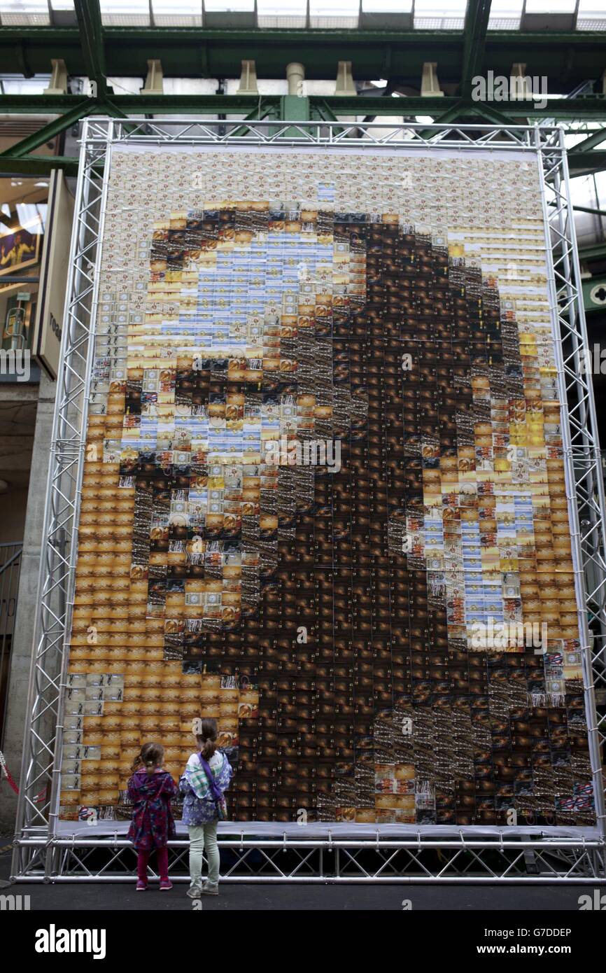 Passers-by look at a 24 metre square canvas, made from 1,485 postcards of actor Kiefer Sutherland in character as Jack Bauer from television drama 24, on display at Borough Market in London which was used as a filming location to mark the Blu-ray and DVD release of 24: Live Another Day on Monday October 6. Stock Photo