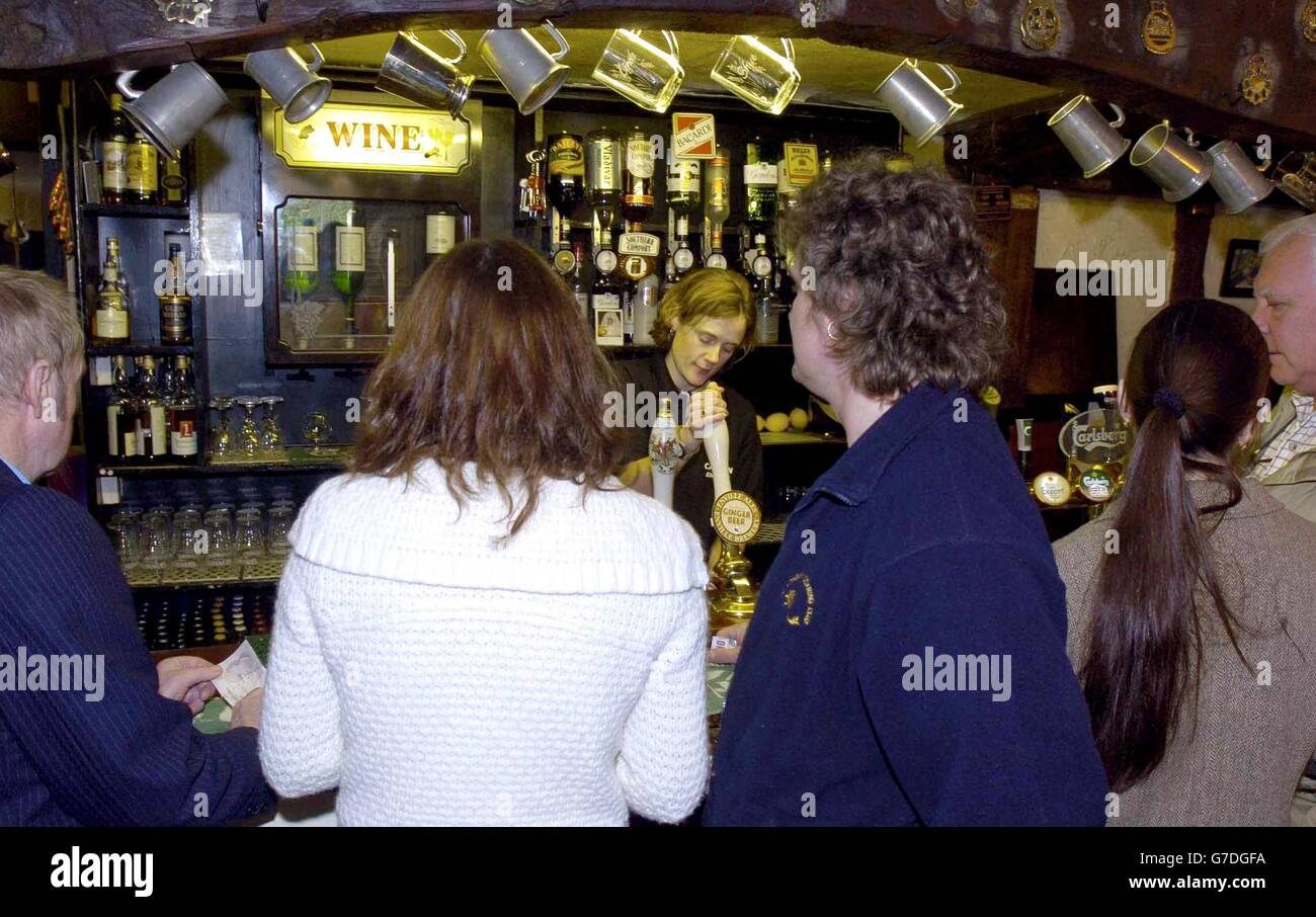 Barmaid Sue King (centre) pulls pints for the customers at the The Cat Inn, in Enville, South Staffordshire, as the pub opens its doors on a Sunday for the first time in 300 years. The publisc house has been shut on a Sunday since a decree by the local landowner in the 18th century. Stock Photo