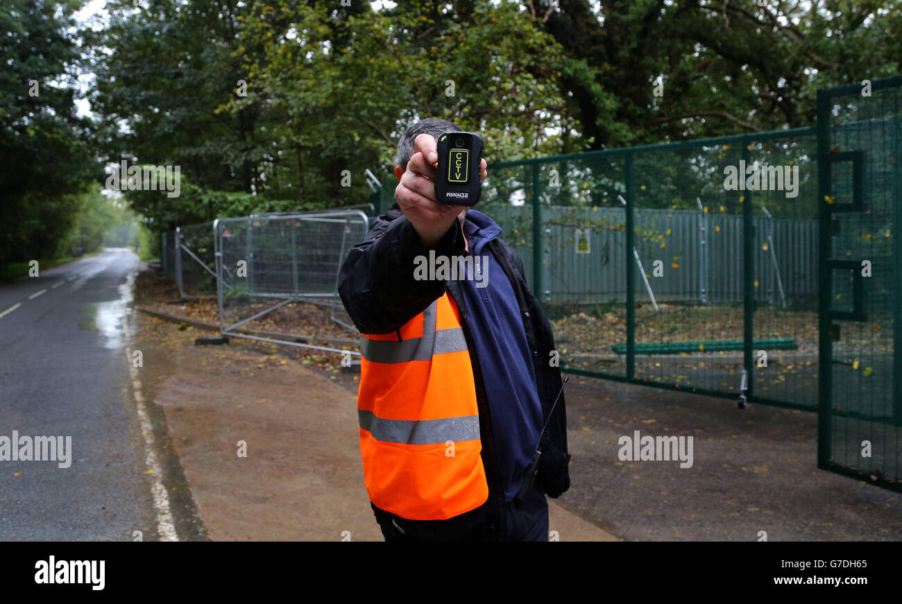 A security guard films the media outside Horse Hill Developments in