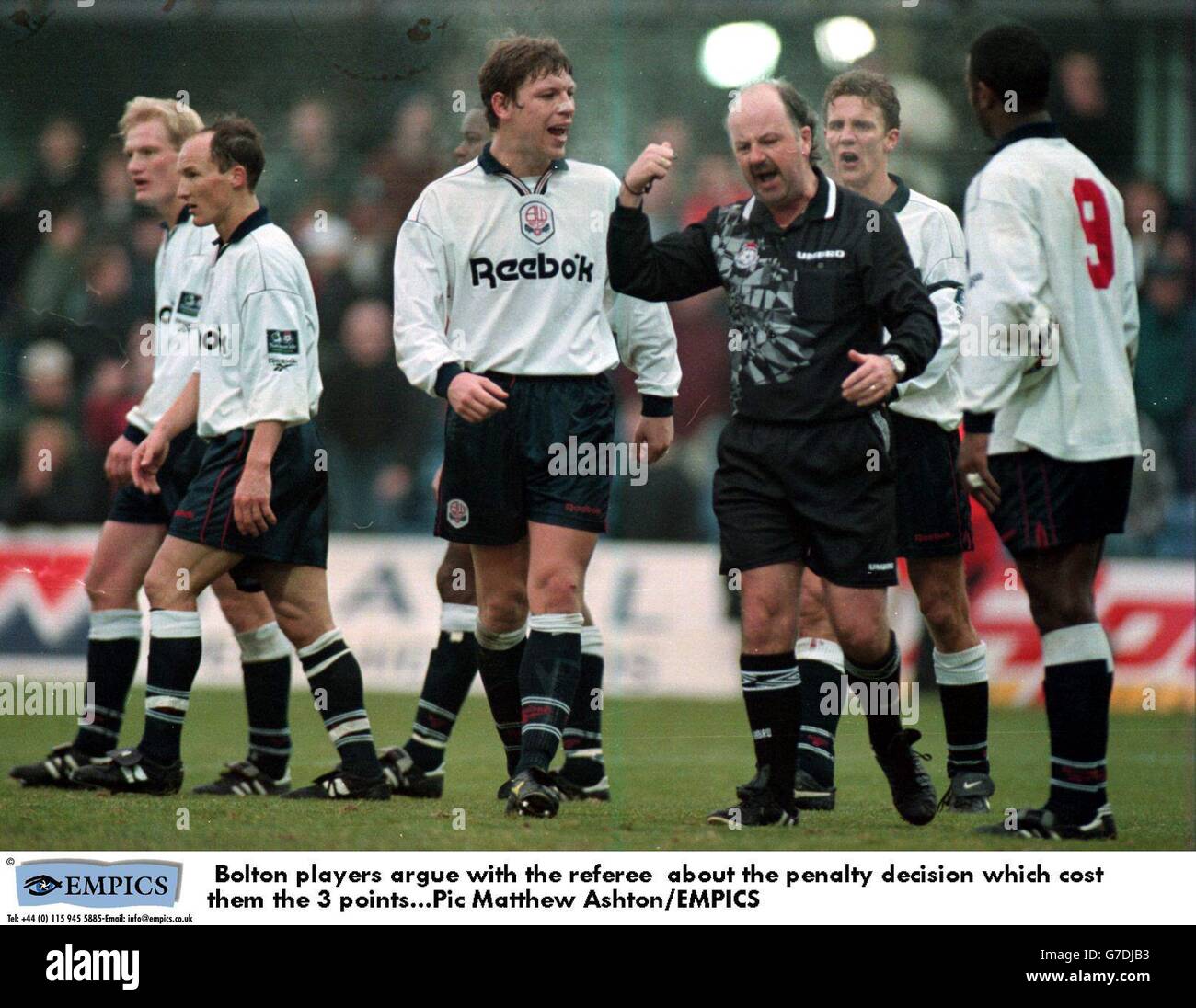 Bolton players argue with the referee about the penalty decision which