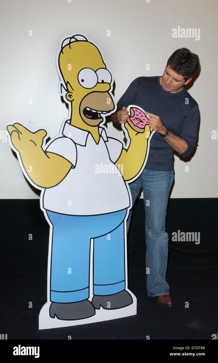 Simon Cowell poses with a cardboard cut-out of cartoon character Homer Simpson, as he arrives for the UK premiere screening of Smart and Smarter - a new episode of The Simpsons on Sky One - in which he stars, at the Rex Cinema and Bar, Rupert Street, central London. Stock Photo
