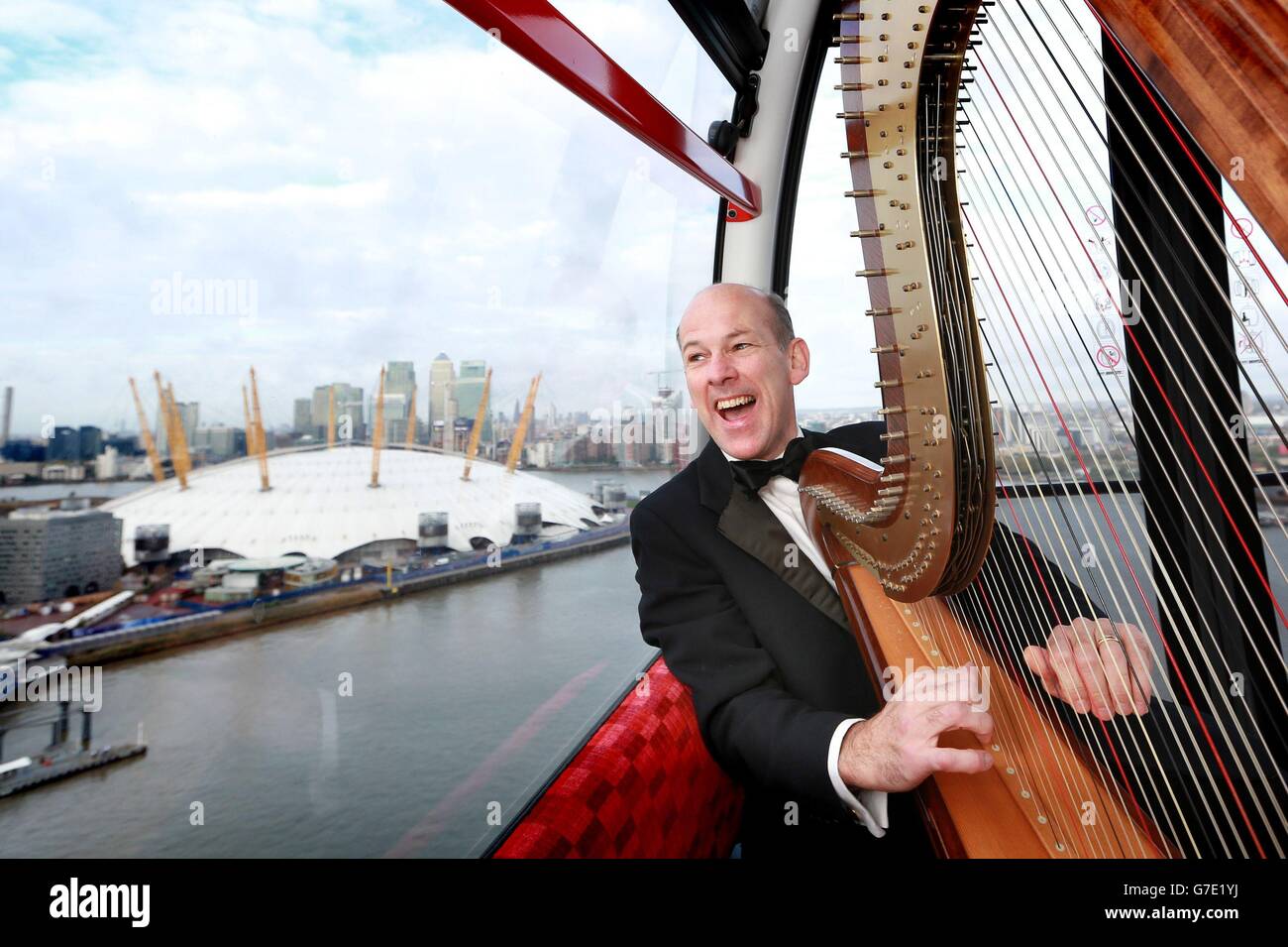 Harpist Rupert McShane from the Salomon Orchestra as he helps celebrate The  Classical Season at The O2 with a&Ecirc;performance onboard the Emirates  Air Line in Greenwich, south east London Stock Photo -