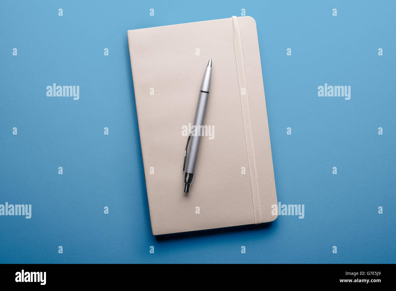 top view of blank notebook with pen on blue background Stock Photo