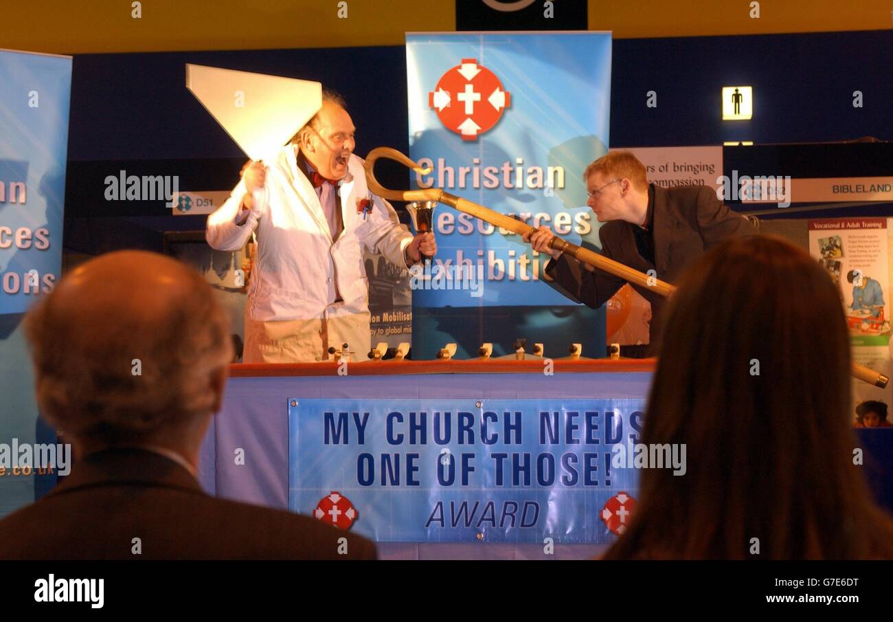 A self-styled 'mad engineer' who invented a low-cost, lightweight handbell in his garden shed out of aluminium off-cuts, a broom handle and a rubber ball was today awarded a church award for innovation. Maurice Davies's 'Belleplates' beat competition from other new designs, including a solar-powered talking Bible and Harry Potter 'everlasting' candles, to win the McNoot or 'My Church Needs One of Those' Awards. MCNOOT WINNER MORRIS DAVIES with his BELLEPLATES at the Christian resources exhibition at Birmingham NEC being dragged off stage by compere RICHARD HASNIP with a giant Bishop's Crook. Stock Photo