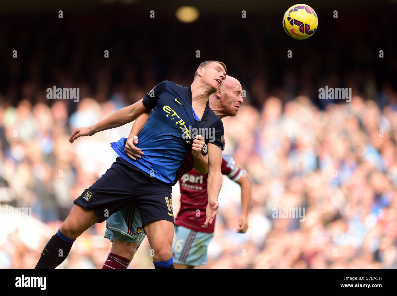 West Ham United's James Collins (right) and Manchester City's Edin Dzeko (left) battle for the ball in the air Stock Photo