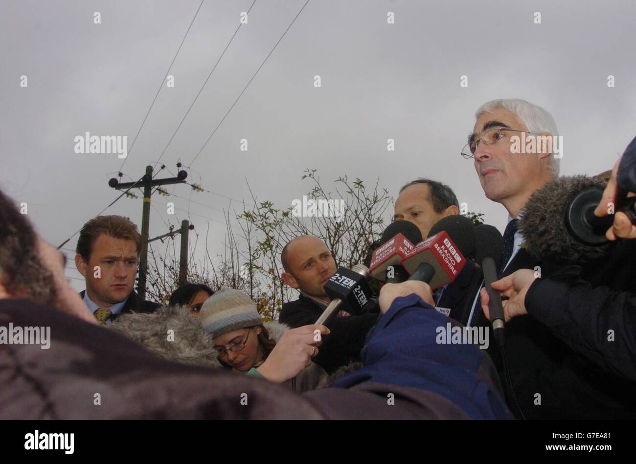 The Transport Secretary Alistair Darling (right) speaks to the press after visiting the scene of the mangled wreckage of the train which derailed after it had hit a car parked on a level crossing at Ufton Nervet in Berkshire. The crash, which has so far claimed seven lives, occurred after the train had left Reading bound for Plymouth. Stock Photo