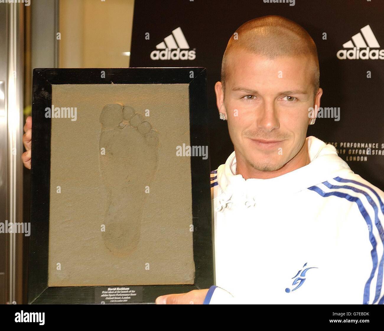 Real Madrid and England footballer David Beckham with a concrete cast of  his right foot, made at the Adidas store in Oxford Street, London. The  Adidas store opens to the public for