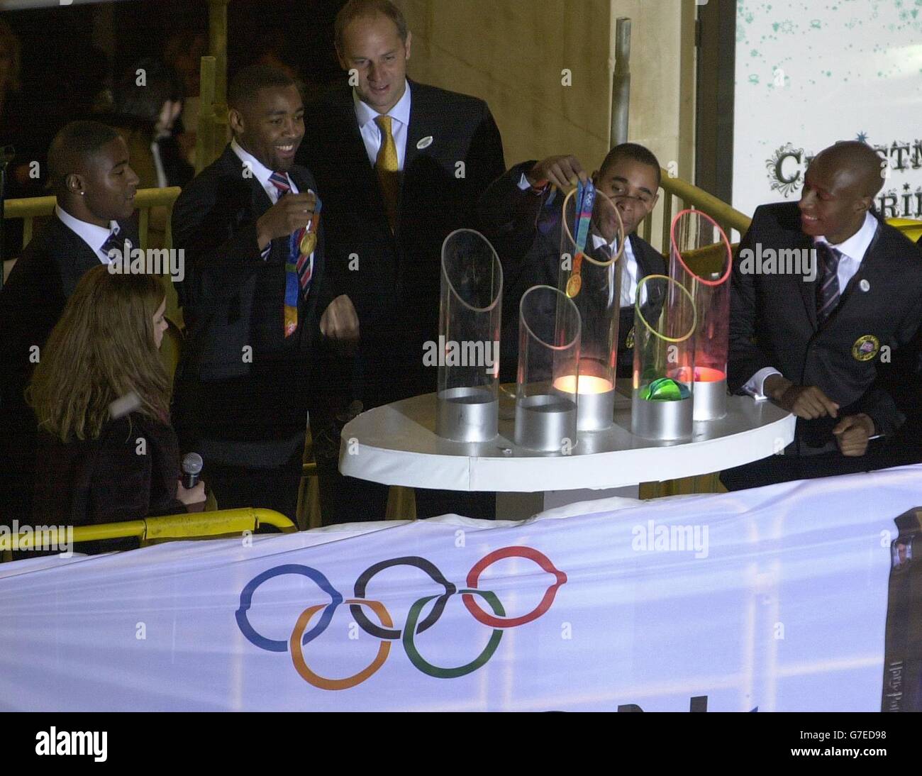 Teenage actress Emma Watson, who plays Hermione Grainger in the Harry Potter films, helps Olympic gold medal winners (l to r) Mark Lewis-Francis, Darren Campbell, Sir Steve Redgrave, Jason Gardner and Marlon Devonish, to turn on the traditional Christmas lights in London's Oxford Street Stock Photo