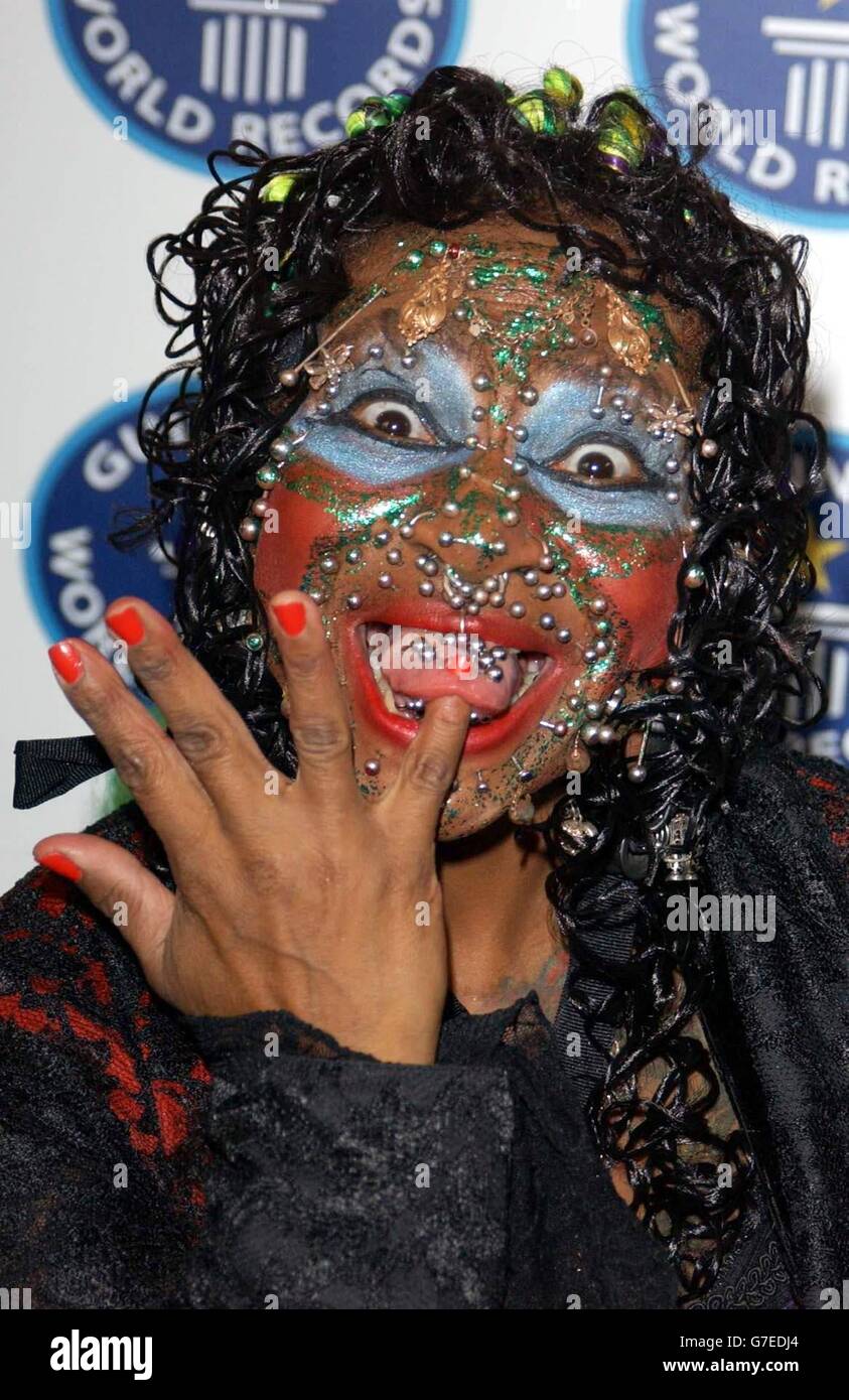 Elaine Davidson, the world's most pierced woman, pokes her finger through her tongue during a photocall for the 50th anniversary party of the Guinness Book of Records, held at the Royal Opera House in London. Stock Photo