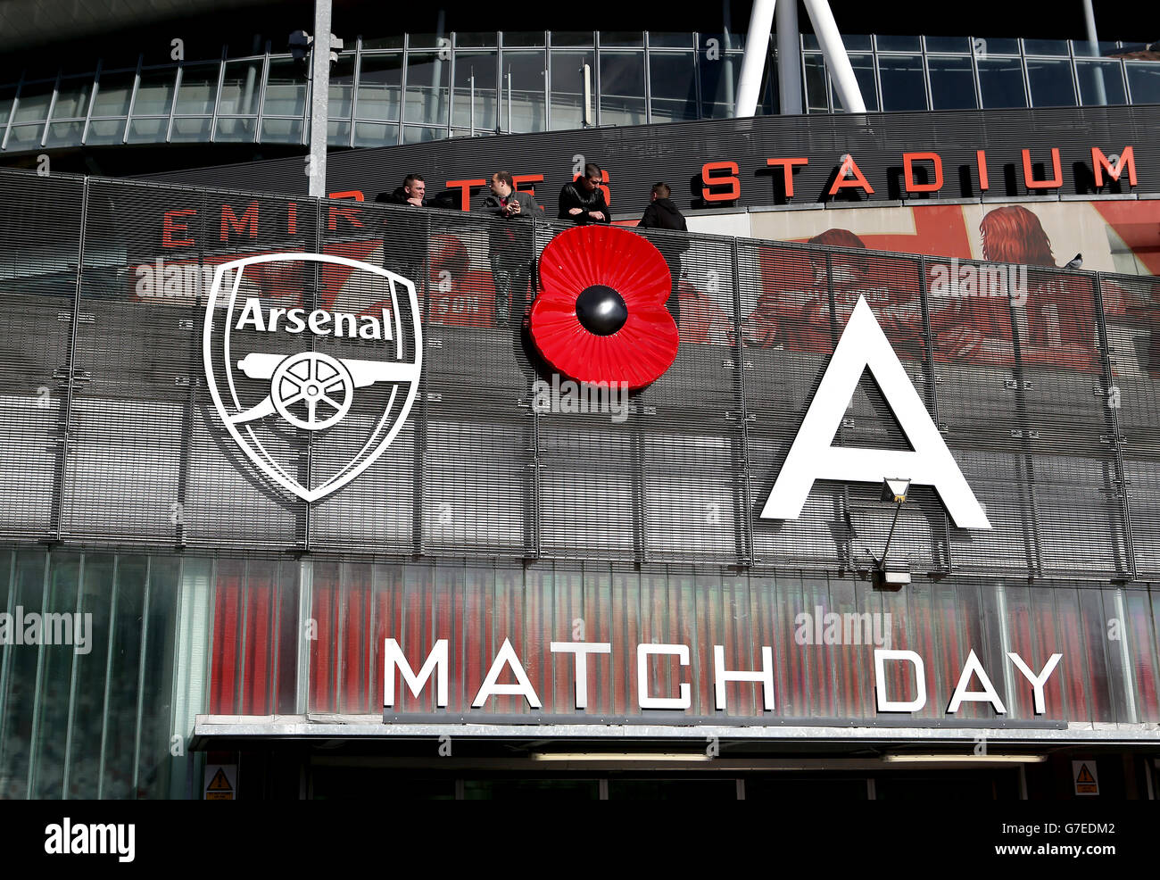 General view of a large poppy outside the Emirates Stadium next to the club badge Stock Photo