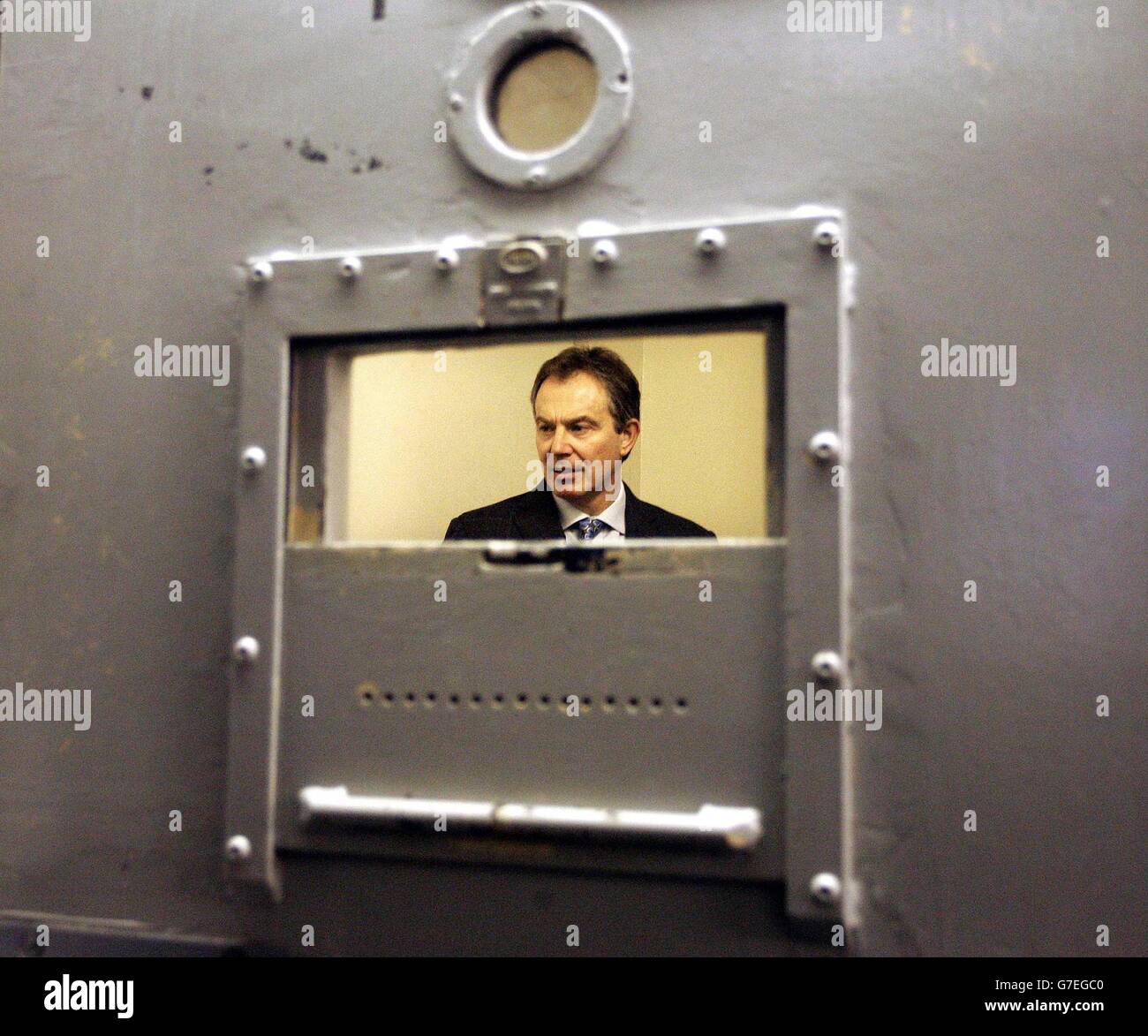 Britain's Prime Minister Tony Blair stands in a cell during a visit to Slough police station near London. Mr Blair and the Home Secretary David Blunkett arrived in the Berkshire town on the 2.18 from Paddington before being driven to the police base to be shown around by Superintendent Brian Langston, area commander for Slough. The Prime Minister endorsed a series of law changes aimed at rebalancing the judicial system in favour of law-abiding citizens and victims of crime rather than the offenders themselves. Stock Photo