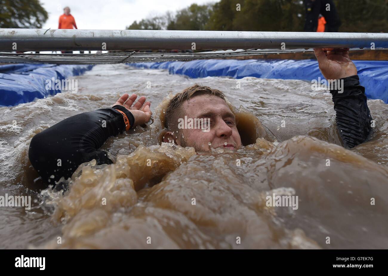 A participant takes on 'Cage Crawl' during Tough Mudder London South at The Matterley Bowl in Winchester, Hampshire. Stock Photo