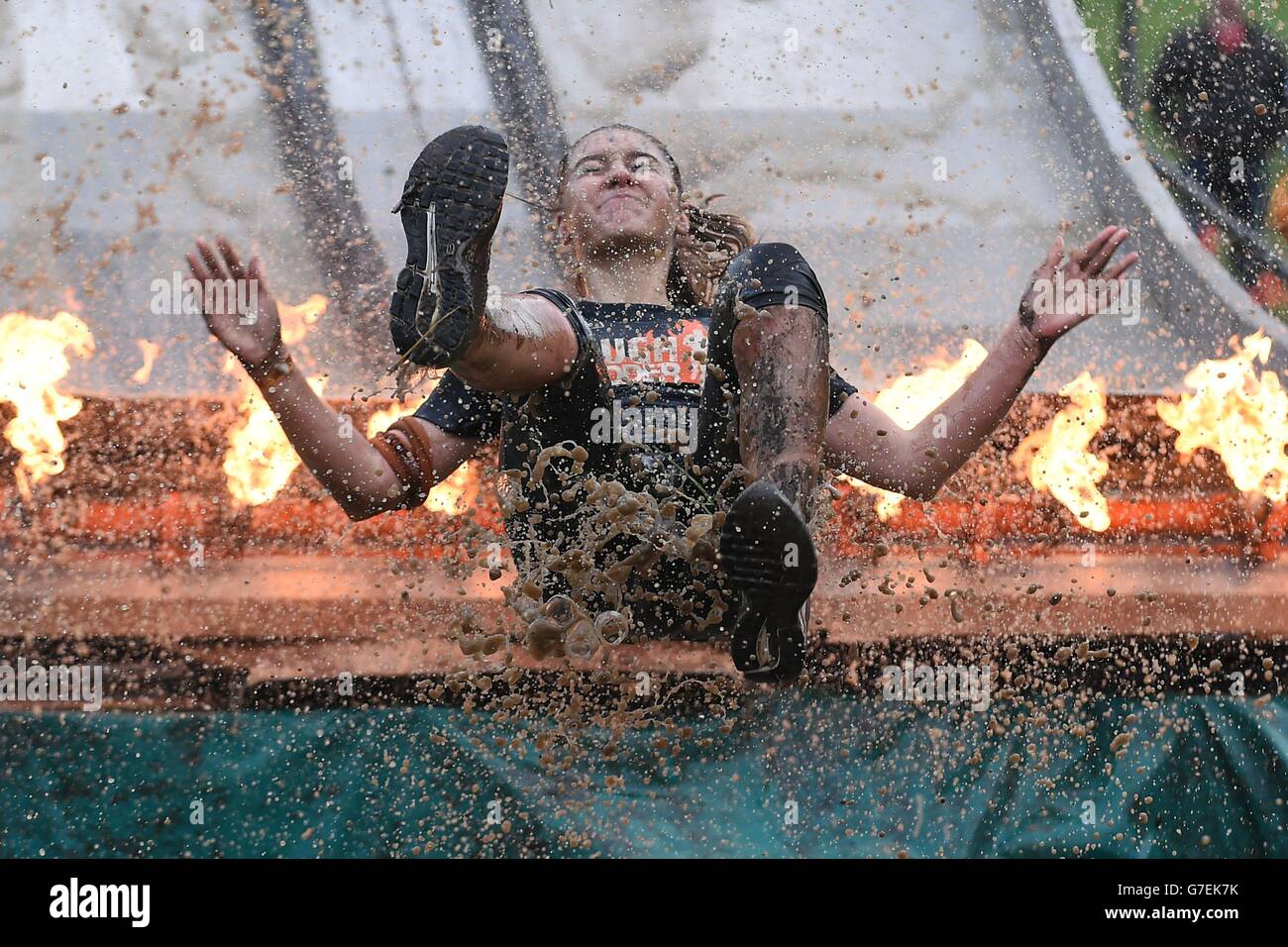 A participant slides down 'Fire in your Hole' during Tough Mudder London South at The Matterley Bowl in Winchester, Hampshire. Stock Photo