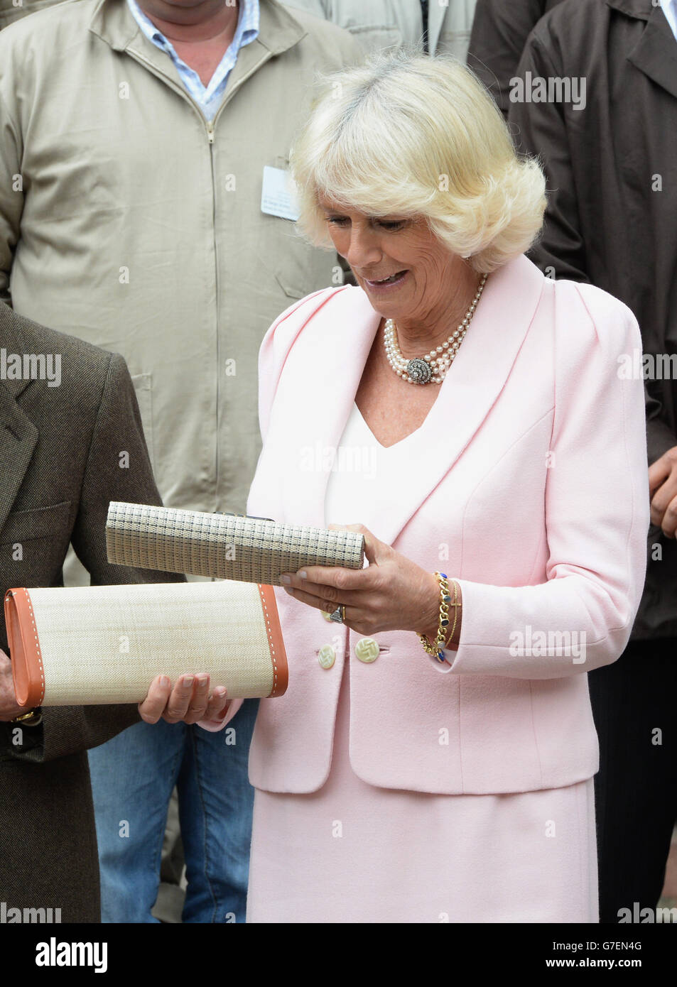 The Duchess of Cornwall is presented with a a clutch bag by teacher Magly Palacios during a visit to Escuela de Artes Y Oficios Arts and Crafts School, Bogota, Colombia, on the second day of the Prince of Wales and Duchess of Cornwall's tour to Colombia and Mexico. Stock Photo