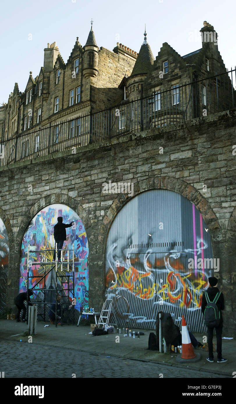 Graffiti artists start work on Scotland's largest street art project in the heart of Edinburgh's Old Town where series of ever-changing canvases will span almost half a kilometre. Stock Photo