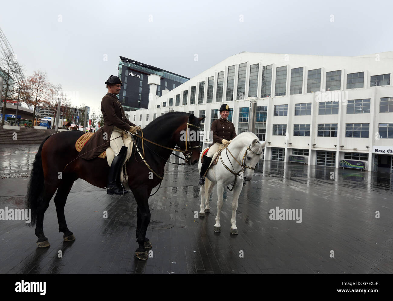 Members of the Spanish Riding School of Vienna Rider Herwig Radnetter (left) riding Pluto Sambata and First Chief Rider Wolfgang Eder with his horse Pluto Malina pose in front of Wembley Stadium in west London where the riding school are performing at Wembley Arena from Friday to Sunday. Stock Photo