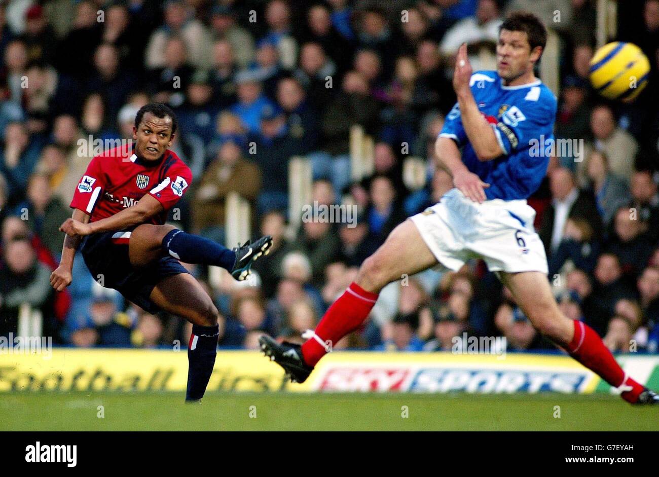 West Bromwich Albion's Robert Earnshaw shoots past Portsmouth's Arjan de Zeeuw during their Barclays Premiership match at Fratton Park, Portsmouth Saturday 4th December, 2004. Stock Photo