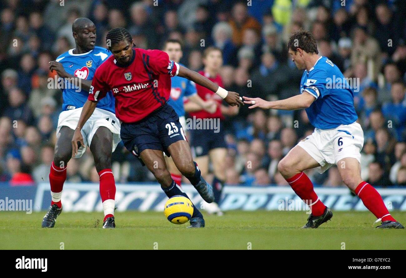 West Bromwich Albion FC's Kanu slips between captain of Portsmouth Arjan De Zeeuw (right) and Andy Faye during their Barclays Premiership match at Fratton Park in Portsmouth, Saturday December 4, 2004. Full time score 3:2. Stock Photo