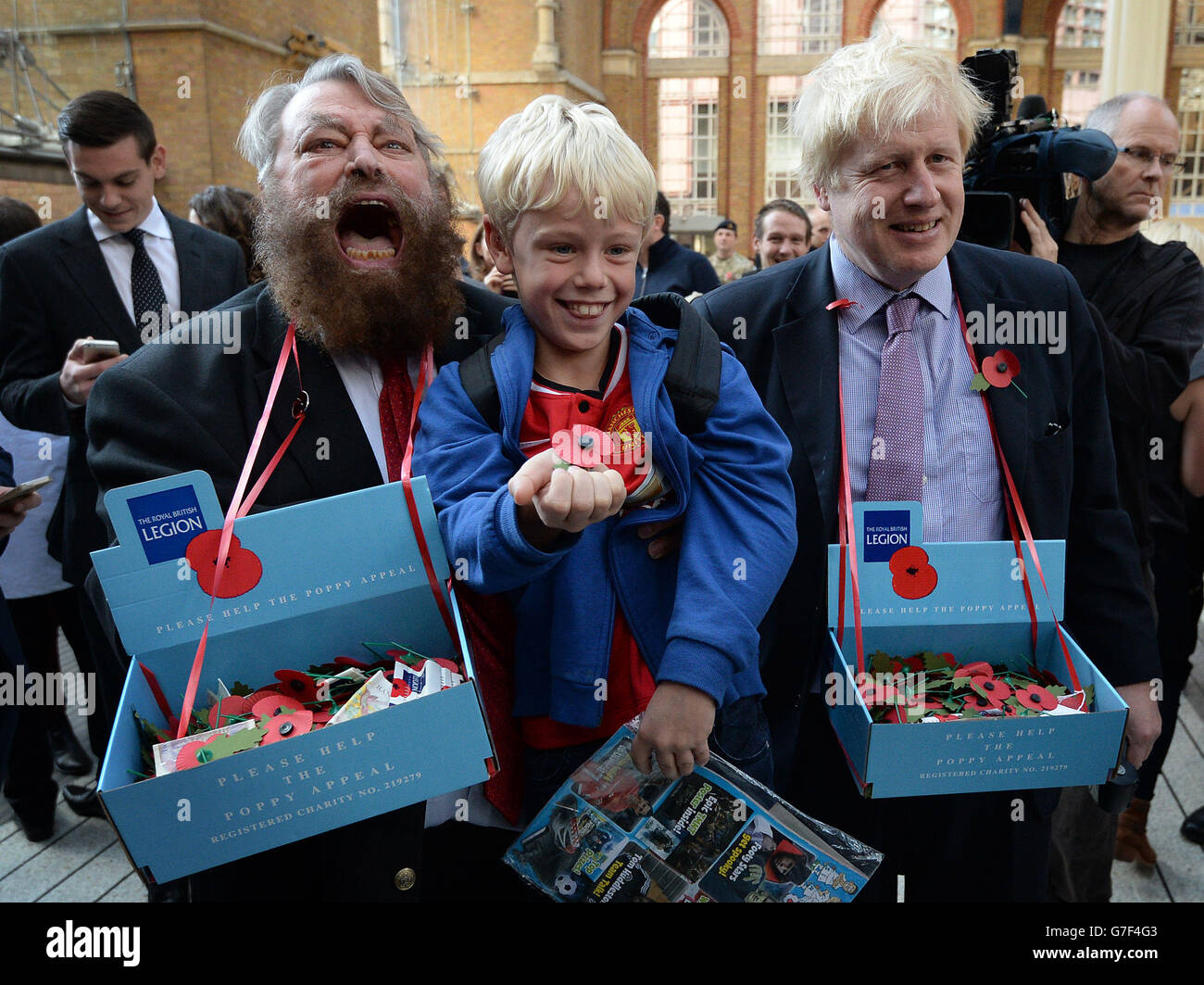 Actor Brian Blessed (left) and Mayor of London Boris Johnson sell poppies in Liverpool Street Station in central London with they collected money from commuters including nine year old Arthur Crowley (centre) from Salisbury. Stock Photo