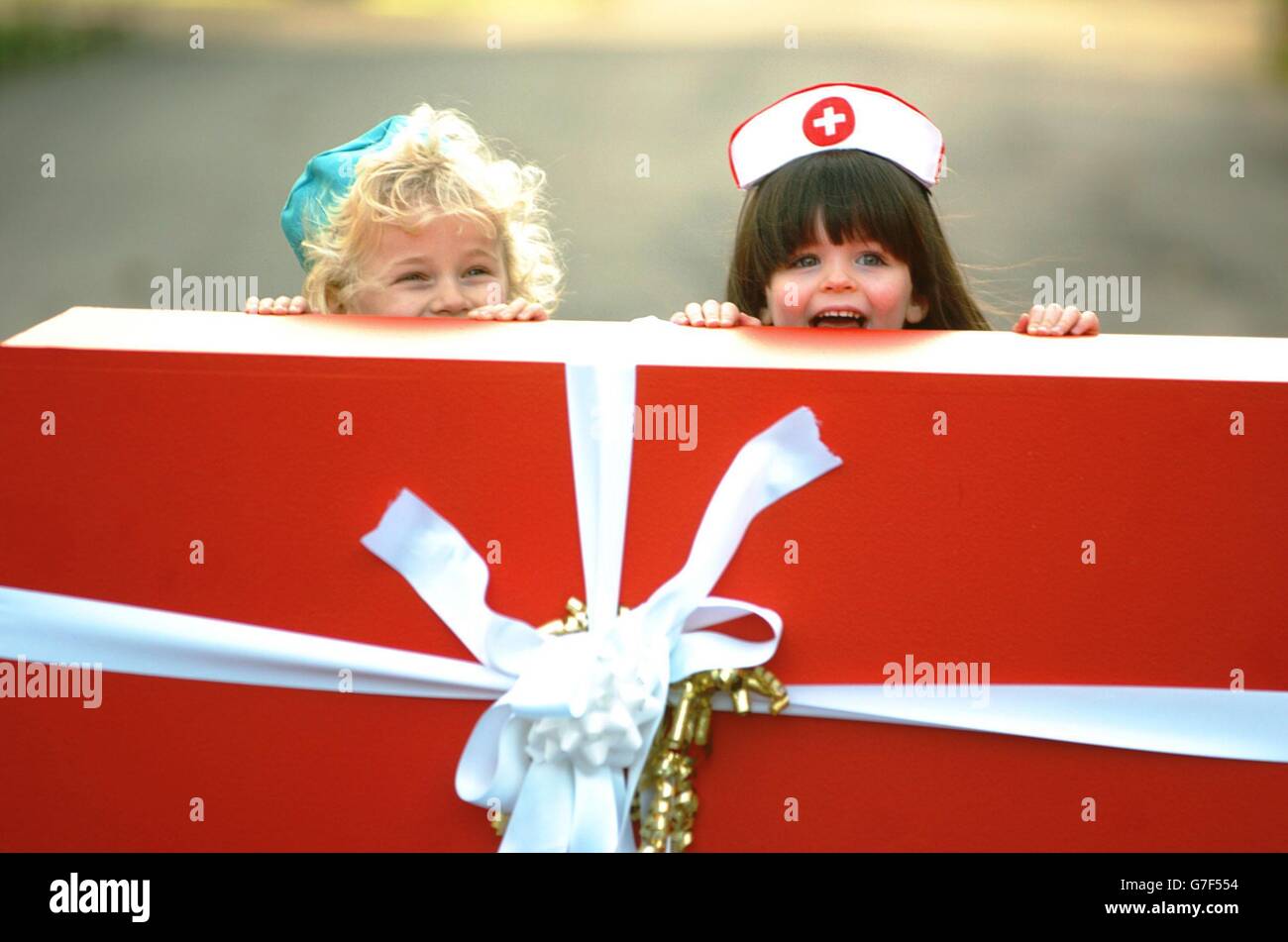 Four year olds Mark Sexton and Megan Gallagher in 'doctors' and 'nurses' costume accept a 'giant birthday gift' on behalf of the Irish Cancer Society from Musgrave SuperValu Centra of 125,000 EURO, to mark the 25th Anniversary of SuperValu and Centra stores in Ireland, St.Stephen's Green, Dublin, Ireland. Stock Photo