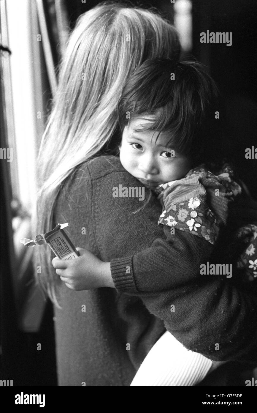 Tam Wolley, two, was rescued from the Galaxy crash at Saigon. Now he is in the arms of a helper at the Ockenden Venture centre in Haslemere, Surrey. He was among children flown to Britain in the 'baby lift' flight that landed last night. Stock Photo