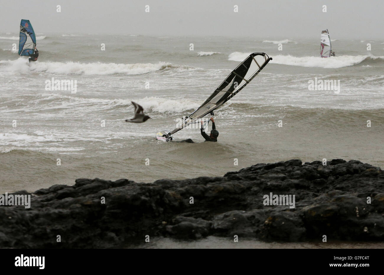 Windsurfers makes the most of the adverse weather conditions in Portmarnock, Dublin. Stock Photo