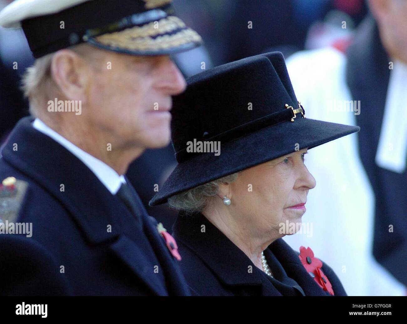 Britain's Queen Elizabeth II with the Duke of Edinburgh observing a minute's silence after planting a wooden Remembrance Cross bearing a scarlet poppy during a service to mark Armistice Day at the Field of Remembrance in the grounds of London's Westminster Abbey. Hundreds of small wooden crosses, planted in the grounds of the Abbey and adorned with a blood-red poppy, bear the name of a fallen loved one and message of commemoration. 13/11/04: The brave men and women who have given their lives in protecting Britain will be honoured in the annual Festival of Remembrance. The Queen and Duke of Stock Photo