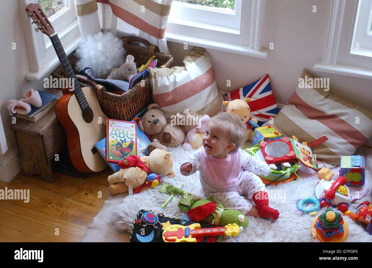 A small child plays at home in London. The Government, together with the Conservative Party have announced pledges to improve the availability of child care to working parents. Stock Photo