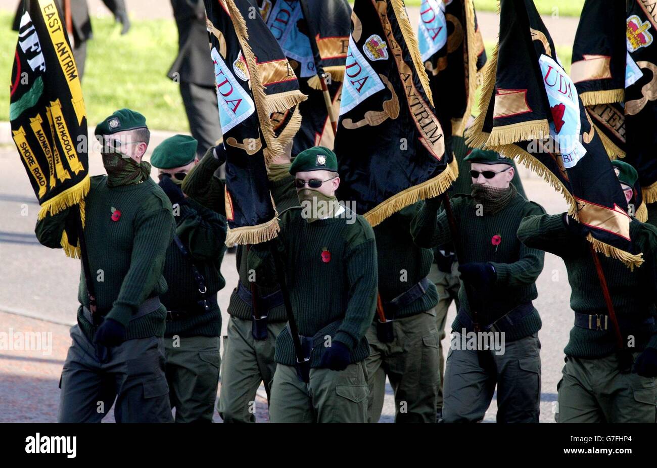 A masked Ulster Defence Association (UDA) colour party leads hundreds of its members to a Remembrance Day service in the Rathcoole estate, a loyalist stronghold on the outskirts of north Belfast. The UDA, Northern Ireland's largest loyalist paramilitary group, today pledged to end all violence and work towards complete disarmament. The announcement followed the decision of Northern Ireland Secretary Paul Murphy to recognise the UDA ceasefire. Stock Photo