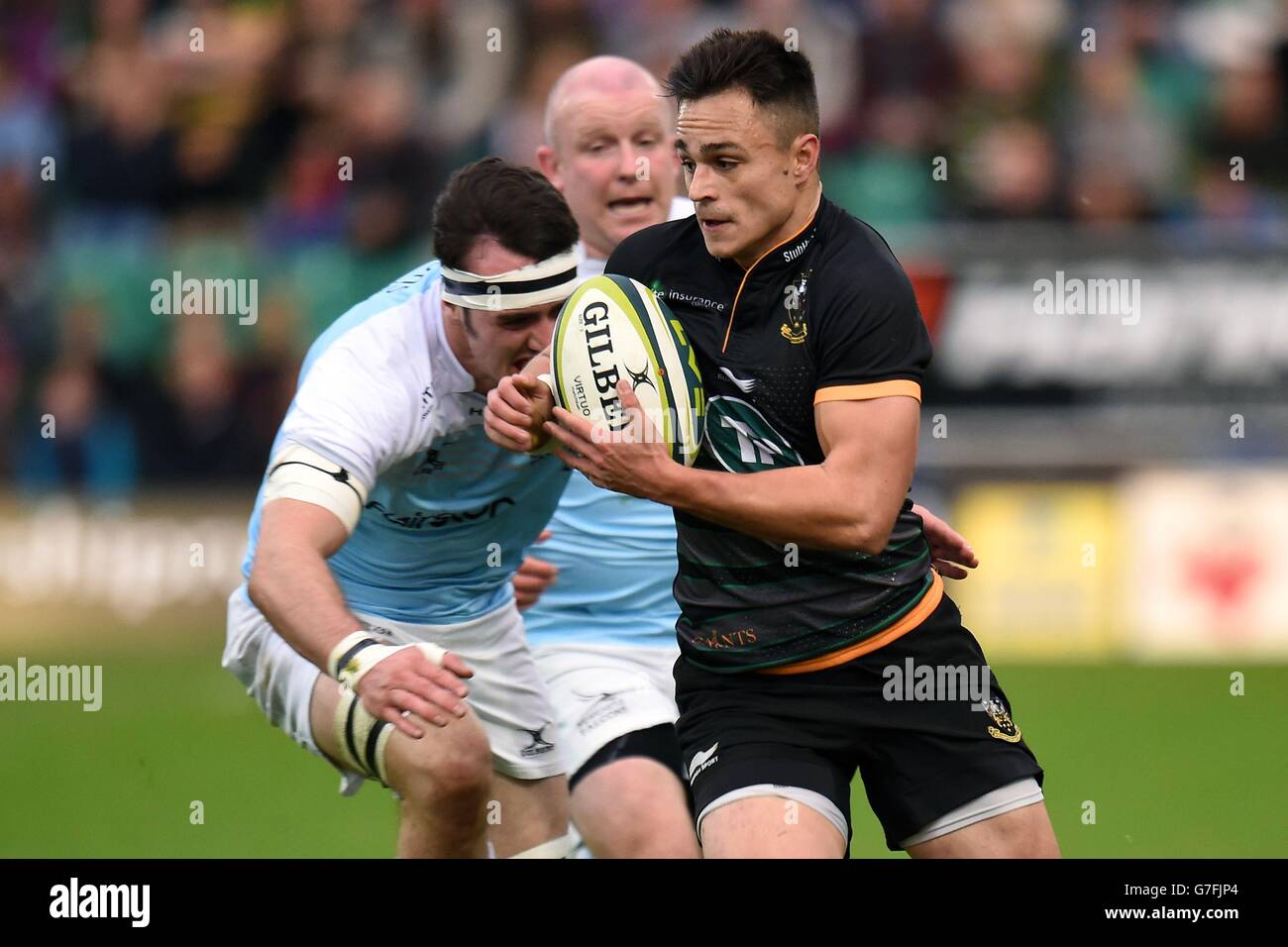 Northampton Saints' Tom Collins (right) breaks the tackle of Newcastle Falcons' Dan Temm (left