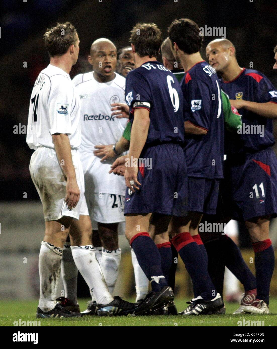 Bolton Wanderers El Hadji Diouf (2nd from left) is pulled away from Portsmouth captain Arjan De Zeeuw during the Barclays Premiership match at the Reebok Stadium, Bolton. 30/11/04: Striker Diouf will serve an immediate three-match ban after admitting a charge of improper conduct for spitting. The Senegal international was charged by the Football Association yesterday after spitting in the face of Portsmouth's Arjan de Zeeuw at the weekend. . Stock Photo