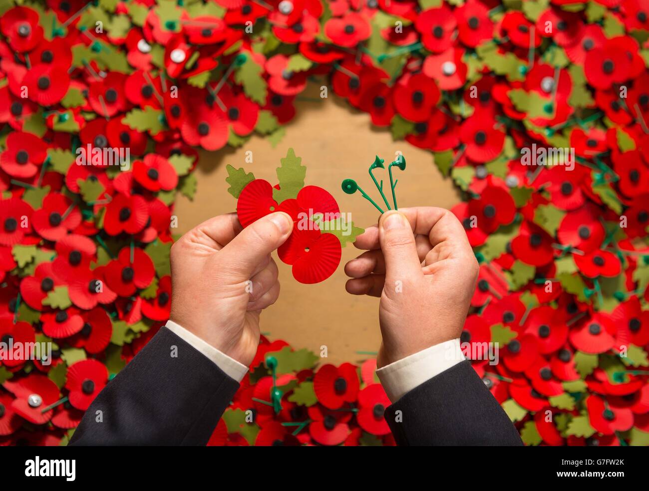 Army veteran Shane Crowhurst pieces together a paper poppy at the Royal British Legion Poppy Appeal in Aylesford, Kent, which is one of the thousands of paper poppies that will be recycled through Sainsbury's after Armistice Day this year. Stock Photo