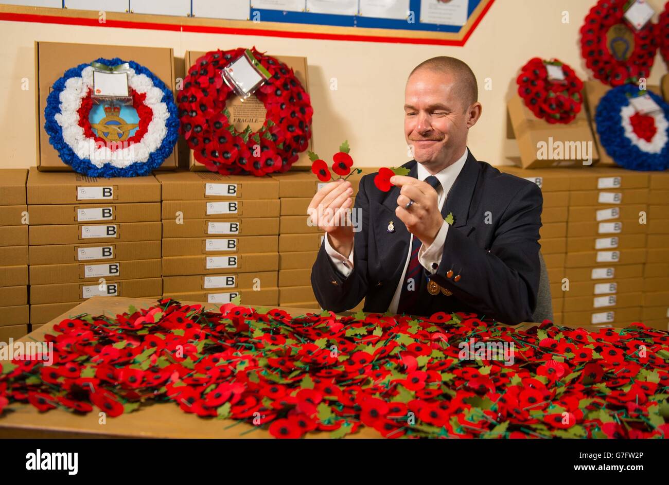 Army veteran Shane Crowhurst pieces together a paper poppy at the Royal British Legion Poppy Appeal in Aylesford, Kent, which is one of the thousands of paper poppies that will be recycled through Sainsbury's after Armistice Day this year. Stock Photo