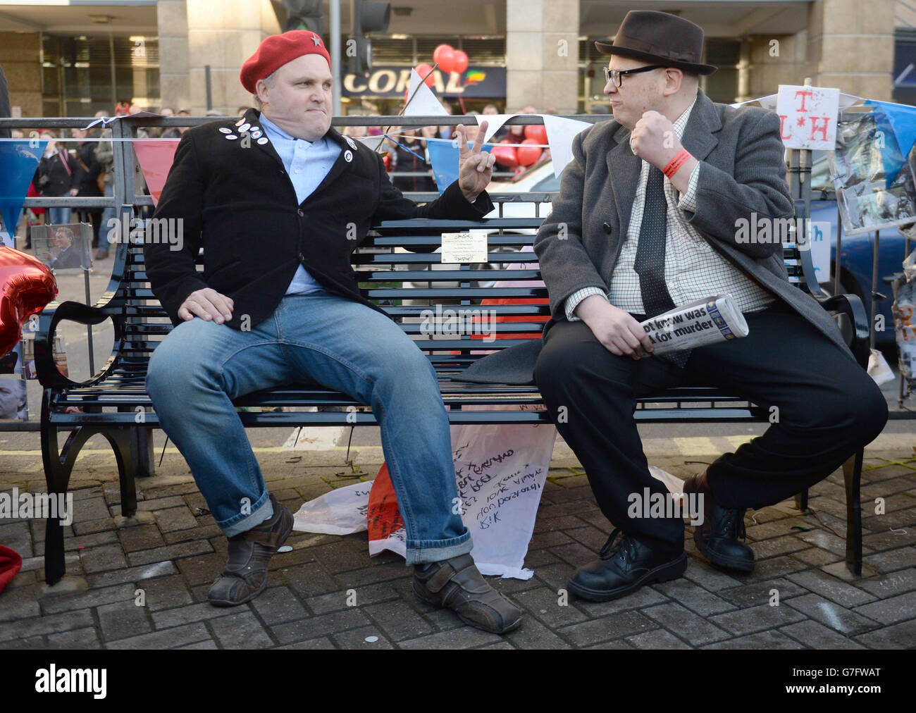 Fans Mark Adams (left) and Lawrence Harman (right) dress as characters Richie Richard and Eddie Hitler from the Comedy TV series Bottom, as a bench celebrating the life Rik Mayall is unveiled by fans at the site where the credits were filmed on Queen Caroline Street, Hammersmith, London. Stock Photo