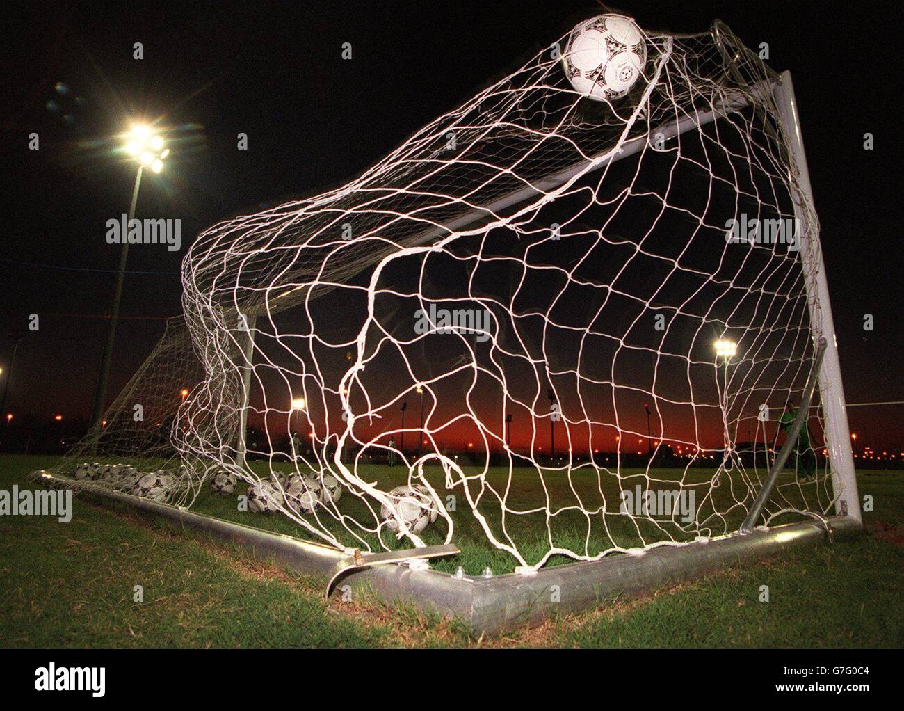 GOAL ! A Ball enters the net in a sunset in Abu Dhabi, United Arab Emirates at the Zayed Sports City training ground - Goalmouth and Adidas Tango Balls Stock Photo