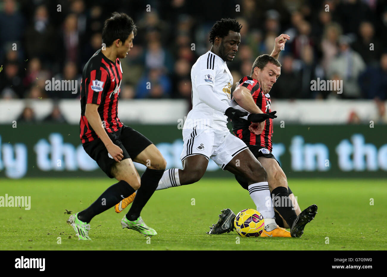 Swansea City's Wilfried Bony is challenged by Queens Park Rangers Yun Suk-Young and Richard Dunne during the Barclays Premier League match at the Liberty Stadium, Swansea. PRESS ASSOCIATION Photo. Picture date: Tuesday December 2, 2014. See PA story SOCCER Swansea. Photo credit should read: David Davies/PA Wire. . . Stock Photo