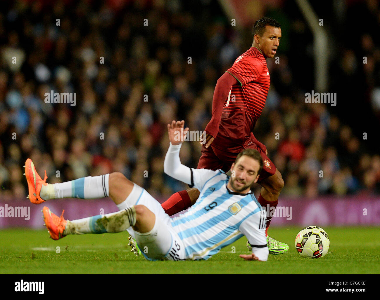 Portugal's Luis Nani skips past Argentina's Gonzalo Higuain during the International Friendly match at Old Trafford, Manchester. PRESS ASSOCIATION Photo. Picture date: Tuesday November 18, 2014. See PA Story SOCCER Argentina. Photo credit should read: Martin Rickett/PA Wire. Stock Photo