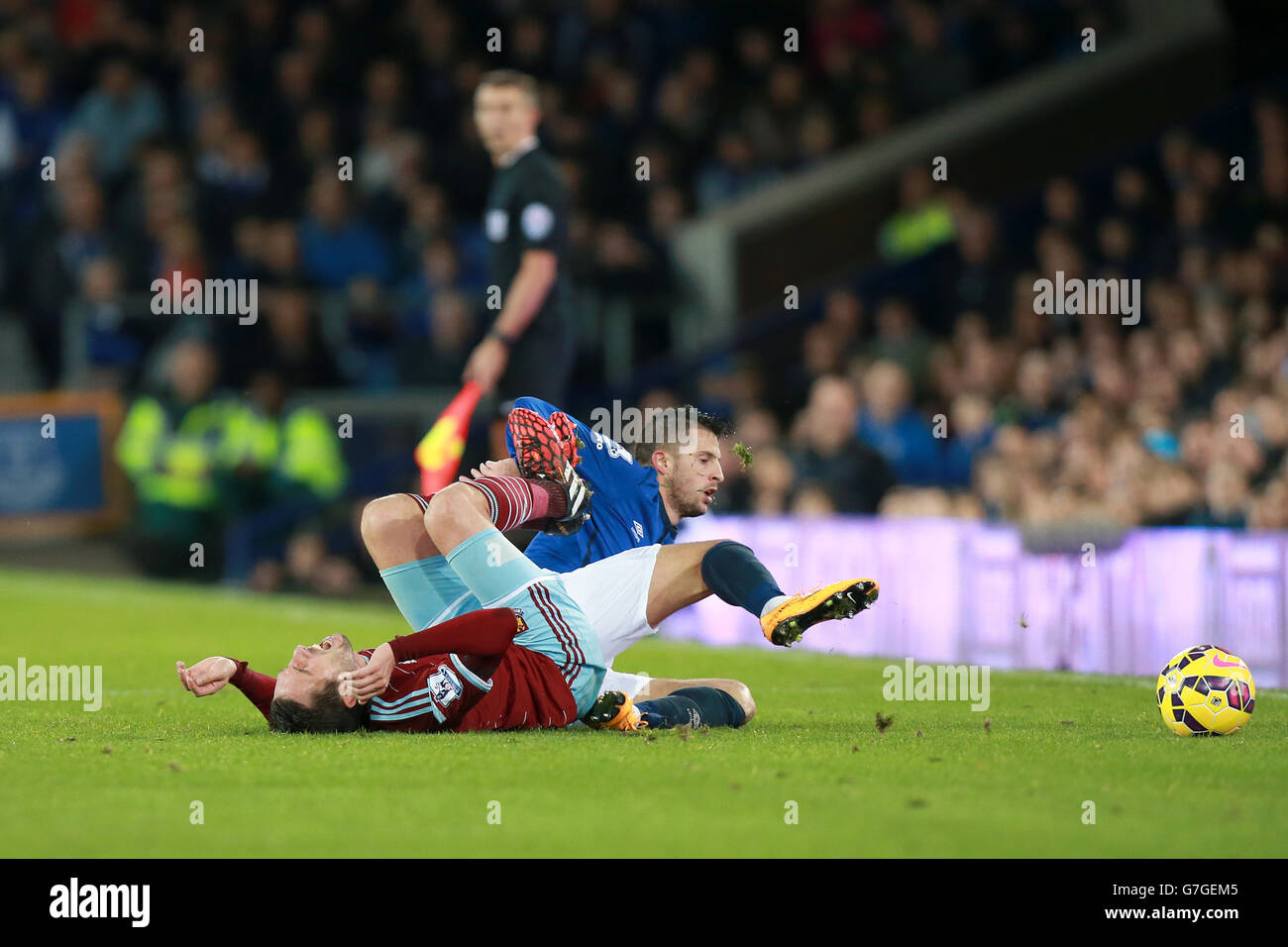 West Ham United's Morgan Amalfitano (left) is brought down by Everton's Kevin Mirallas during the Barclays Premier League match at Goodison Park, Liverpool. Stock Photo