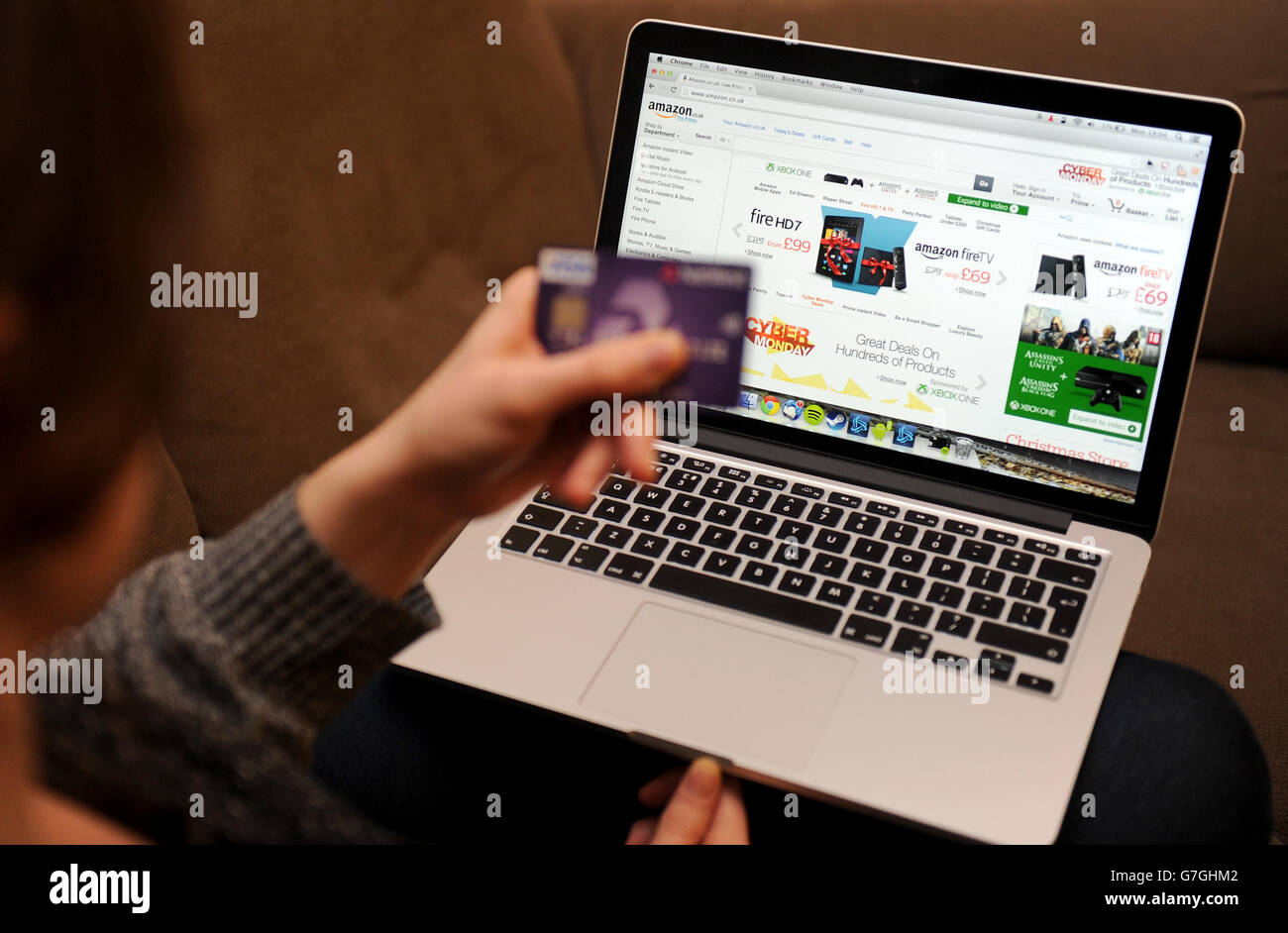 Online Retail Stock. A woman uses a laptop to browse the Amazon website Stock Photo