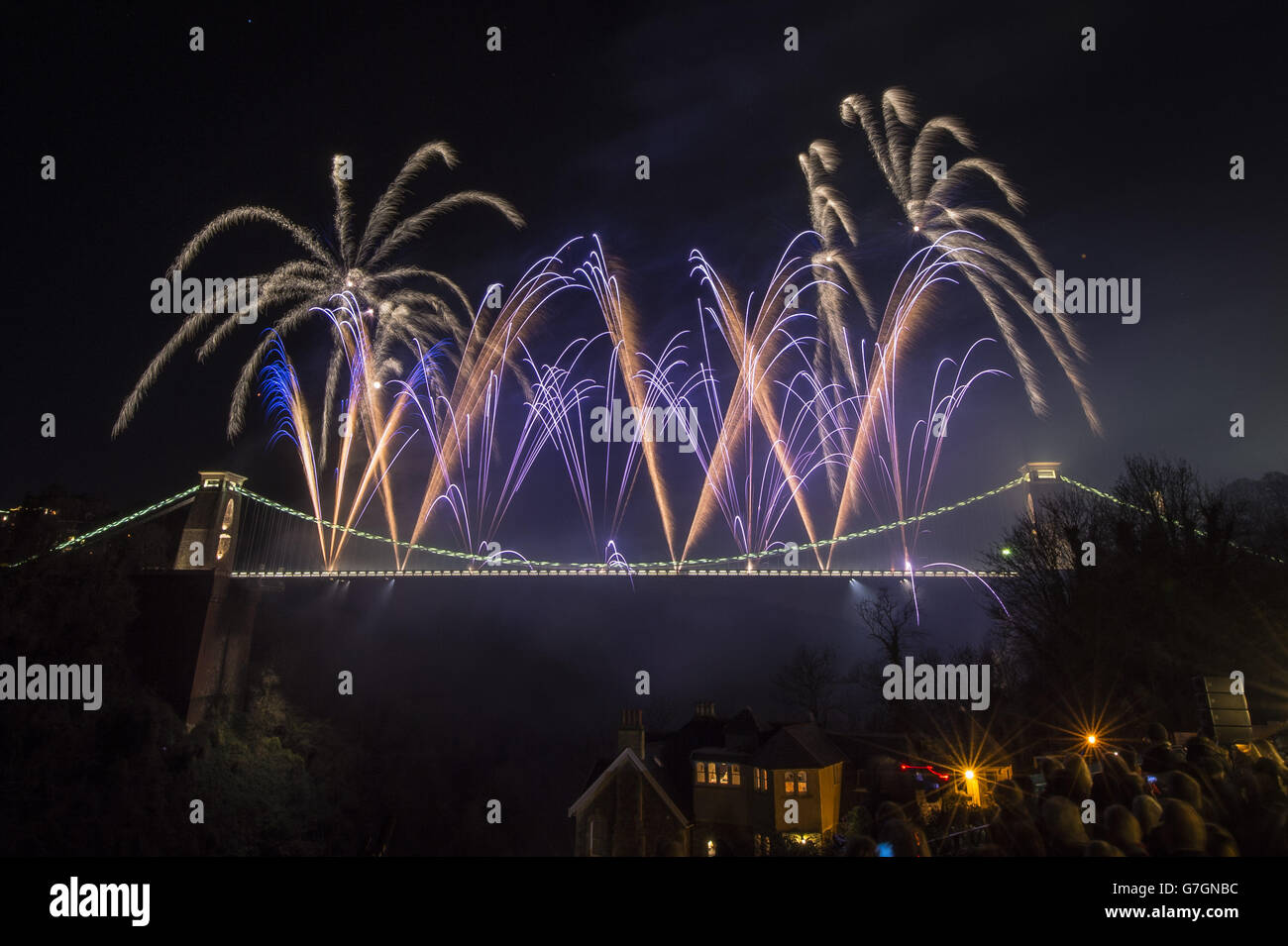 Fireworks explode high above Clifton Suspension Bridge as people watch