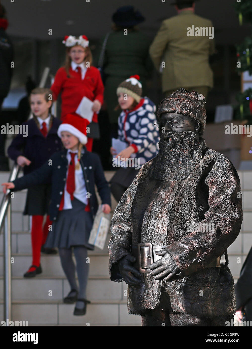 People look at a bronze Santa human statue in the entrance foyer at