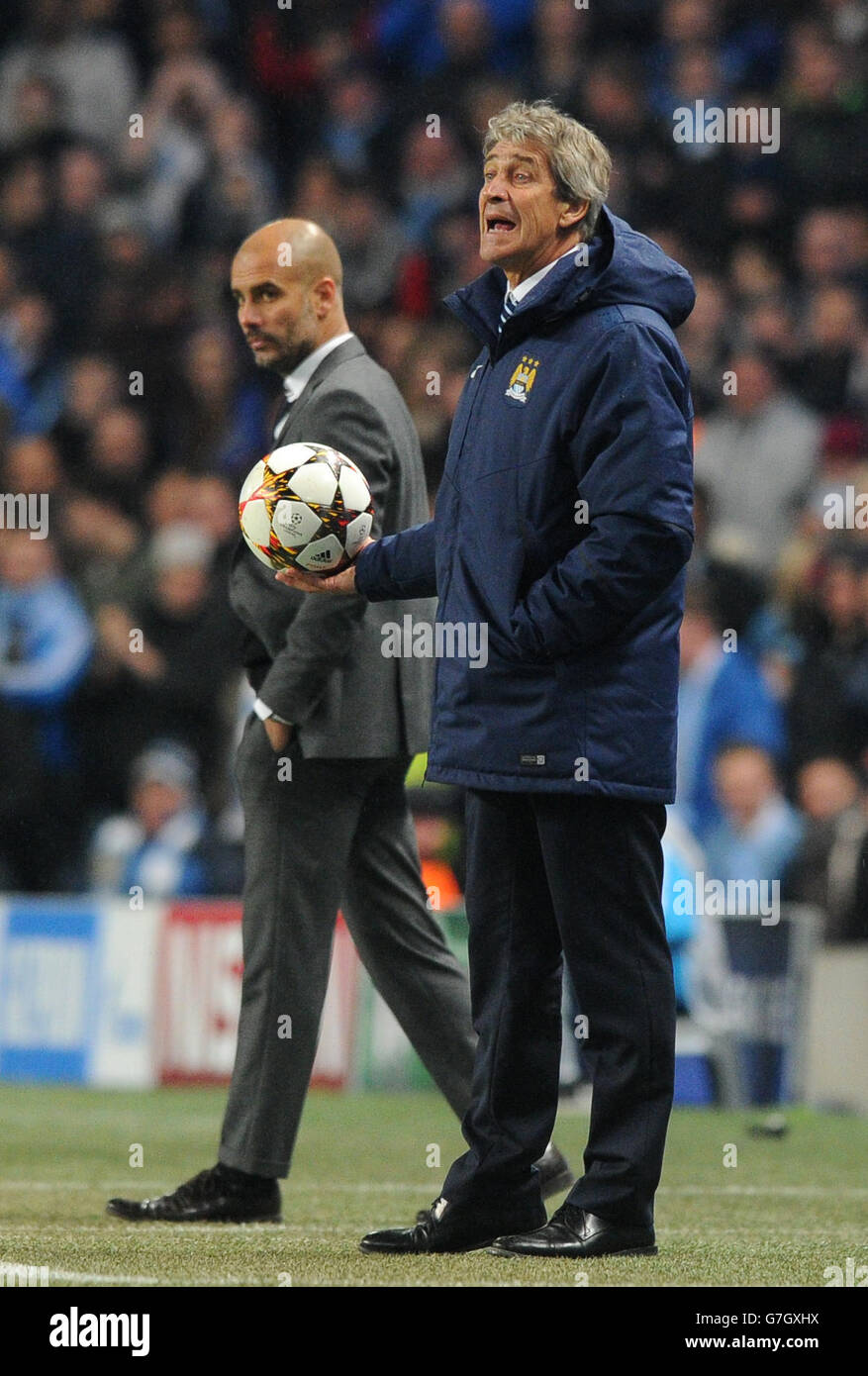 Manchester City manager Manuel Pellegrini (right) and Bayern Munich manager Pep Guardiola on the touchline during the UEFA Champions League match at the Etihad Stadium, Manchester. Stock Photo