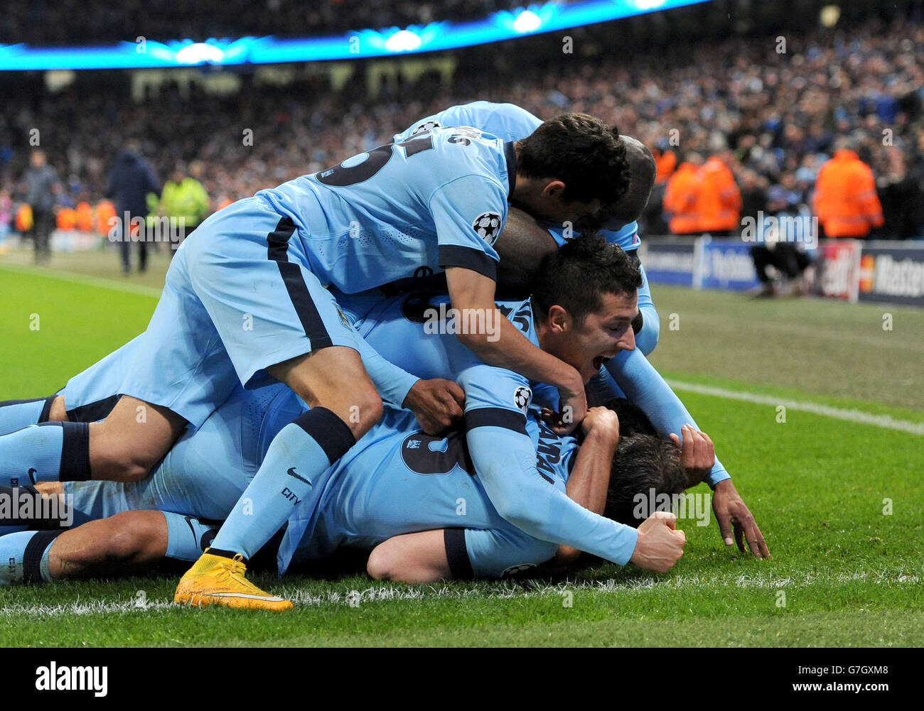 Manchester City's Sergio Aguero (bottom) celebrates scoring his sides third goal of the game alongside teammates during the UEFA Champions League match at the Etihad Stadium, Manchester. Stock Photo